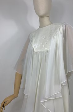 DETAILS - long sheer cape over a sleeveless empire style dress - back zip closure  - floral embroidery yoke - fully lined - poly organza/ viscose  - handmade - dated late 60s early 70s SIZE & MEASURES item laid flat on one side - fits size XS/ S measures available soon CONDITION Excellent vintage condition. https://www.intomycloset.uk/ Summer Dresses With Floral Embroidery And Cape Sleeves, Vintage Sheer Chiffon Dress, Vintage Summer Dresses With Sheer Sleeves, Spring Chiffon Dress With Cape Sleeves, Summer Vintage Dresses With Sheer Sleeves, Spring Wedding Dresses With Cape Sleeves, Spring Dress With Cape Sleeves And Floral Embroidery, Spring Cape Dress In White, White Cape Dress For Spring