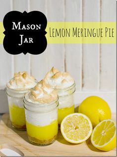 lemon meringue pie in mason jars on a cutting board with sliced lemons