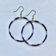 These handmade, beaded hoop, earrings come in a variety of colors. This pair is black with a purple gradient. Perfect for all occasions and super comfortable to wear. These earrings are not heavy at all and can be worn comfortably all day. The earrings are 5 cm across. Every pair is unique and  may look somewhat different than the picture. I love making these earrings and hope you enjoy wearing them! Black Earrings With Colorful Beads, Black Round Earrings With Colorful Beads, Purple Handmade Small Hoop Earrings, Handmade Small Purple Hoop Earrings, Trendy Handmade Black Hoop Earrings, Handmade Black Circular Jewelry, Purple Beaded Hoop Earrings With Round Beads, Purple Beaded Round Hoop Earrings, Trendy Handmade Black Beaded Earrings