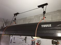 there are two wires connected to the back of a boat in a garage with other tools hanging on the wall