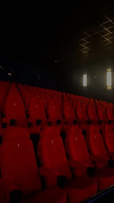 rows of red chairs in an empty theater