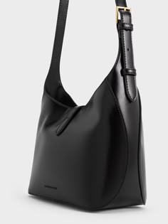 This product is made with at least 20% sustainable materials by weight. CHARLES & KEITH uses recycled, degradable, organic, and water-based materials in our eco-conscious collection. You will always look polished and put together with the Wisteria shoulder bag in tow. It features an elegant black finish that will go with everything in your wardrobe and a gold-toned accent that adds understated glamour to the design while keeping your belongings secure. The shoulder strap is also adjustable so you can carry it at your preferred drop length. Charles Keith Bags, Large Black Handbag, Bag Photography, Understated Glamour, Look Polished, Accessories Bags Shoes, Chic Bags, Charles Keith, Online Shopping For Women