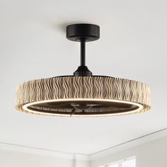 a light fixture in a living room with a zebra print shade hanging from the ceiling