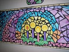 a painting on the wall that has been decorated with candles and flowers in purple, blue, yellow and green colors