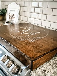 a kitchen counter with a wooden cutting board sitting on it's side next to an oven