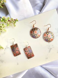 Give a Truly Special Gift with a Handmade Piece by a Skilled Jewelry Artist. We create our copper handmade jewelry with modern printing techniques. 🌟 New version of our best seller. ⁃ Our copper accessories are high quality, durable, and famous paintings are printed in high resolution on engraved natural copper plate. Material: SURFACE TYPE: Copper THICKNESS: 0.4 mm Clasps Type: ⁃ Lobster Claw Sizes: ⁃ Round Diameter : 1.5  in / 4cm  ⁃ Rectangle 1.5 in (4cm) x 1.2 in (3cm) How to Order: - Choose quantity and add to cart. After you can check our other models and fill the cart, you can make a secure payment via Etsy Payments. - After the order has been completed we will start to prepare your package for delivery. Please don't forget to add your contact number for fast and trouble-free shipp Multicolor Nickel-free Copper Earrings, Nickel-free Multicolor Copper Earrings, Multicolor Copper Dangle Earrings, Handmade Multicolor Copper Earrings, Artisan Multicolor Brass Earrings, Copper Accessories, Copper Plate, Light Weight Jewelry, Jewelry Artist