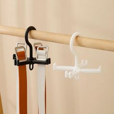 a pair of scissors are hanging on a coat rack with two clips attached to it