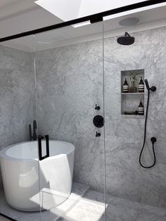 a white bath tub sitting next to a walk in shower