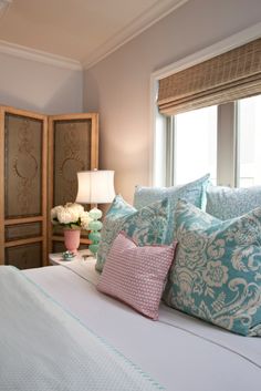 a bed with blue and white pillows in a bedroom