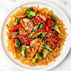 a white plate topped with broccoli, carrots and other veggies