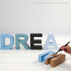 a person cutting letters that spell out the word dream