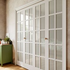 an empty room with white doors and green cabinet next to the bed in the corner