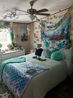 a bedroom with mermaid themed decor and lights on the ceiling