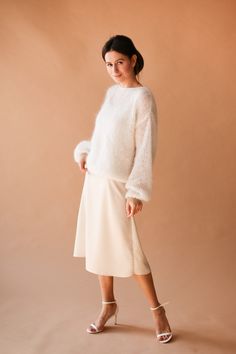 a woman in a white sweater and skirt