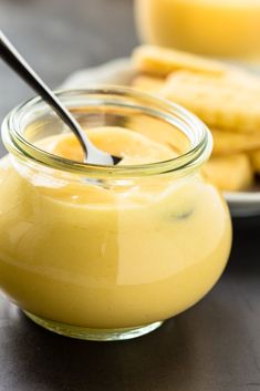 a glass jar filled with food sitting on top of a table next to a plate of crackers