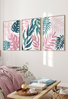 three paintings hang on the wall above a couch in a room with pink and green decor