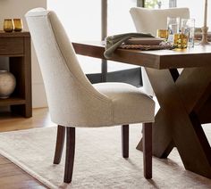 a dining room table with two chairs and a wine glass on the table next to it