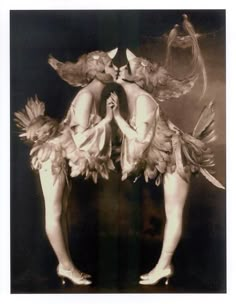 an old photo of two women dressed in costumes with wings and flowers on their heads