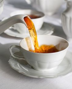 tea being poured into a white cup