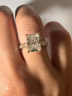 a woman's hand with a diamond ring on top of her finger and an engagement band