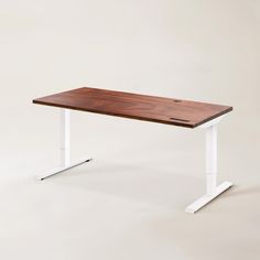 a wooden table sitting on top of a white metal stand up desk with an electric base