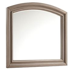 an arched mirror is shown against a white background and it has a light brown frame