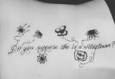 the back of a woman's stomach with flowers and butterflies on it, which says do you suppose she is a wildflower?