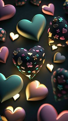 many heart shaped objects are scattered on a black surface with pink, blue and green hearts