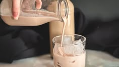 a person pouring something into a glass with ice