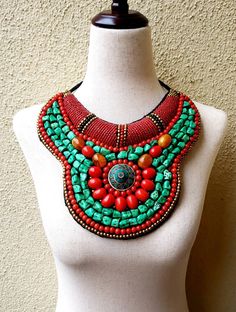 "Stunning handmade Tibetan bib collar necklace in faux teal green turquoise, coral and amber beads, with a stunning central brass medallion. Perfect with a flowing caftan or an itsy black bikini. Perfect anywhere you are barefoot! Wear your hair up, with a bright ribbon or turban, or wear it down! You don't need much else! Eye-catching geometric pattern with a mix of smooth and textured beads. This is a handmade reproduction of a Tibetan tribal neck piece or Skeypuk, which is worn as collars on Handmade Beaded Necklaces For Festivals, Bohemian Turquoise Bib Necklace With Colorful Beads, Handmade Bohemian Green Turquoise Necklace, Handmade Green Turquoise Bohemian Necklace, Bohemian Green Handmade Turquoise Necklace, Unique Bib Necklace With Large Beads For Festivals, Unique Bib Necklaces With Large Beads For Festivals, Handmade Turquoise Bohemian Bib Necklace, Bohemian Red Bib Necklace With Round Beads