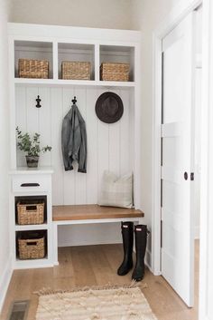 an image of a white bench with baskets and hats on it's back wall