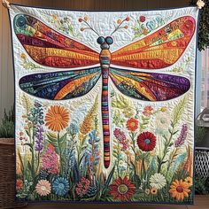 a colorful dragonfly quilt hanging on a wall