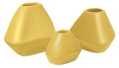 three yellow vases sitting next to each other