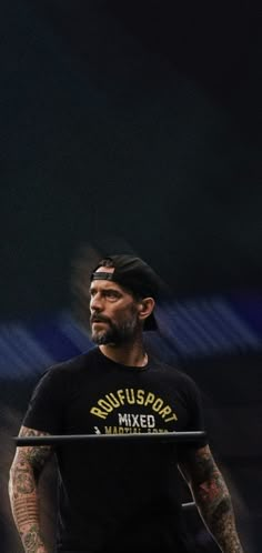 a man with tattoos on his face holding a barbell in front of him and looking up