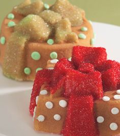 two small cakes on a white plate with green and red decorations, one has a bow