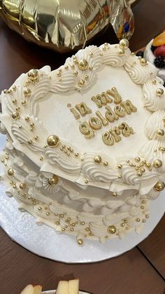 a heart shaped cake on a table with gold decorations and confetti around it