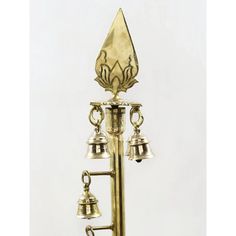 an antique brass clock with bells on it's side and a wind chime in the middle