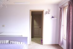 a baby's room with a crib and chandelier hanging from the ceiling