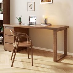 a wooden desk with a chair next to it and pictures on the wall behind it