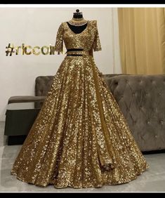 gold sequined gown with black belt on mannequin stand in front of couch