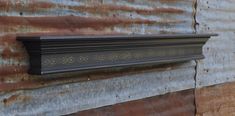 a close up of a metal object on a wall with rusted paint and wood