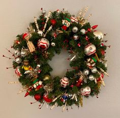 a christmas wreath with ornaments hanging on the wall