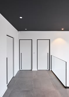 an empty room with white walls and black trim on the doors, is shown in this image