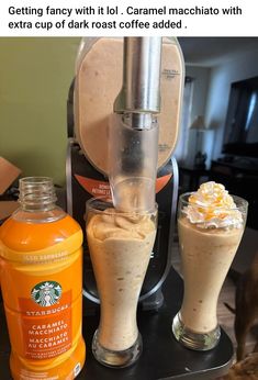 there are two drinks in front of the coffee maker and an orange drink next to it