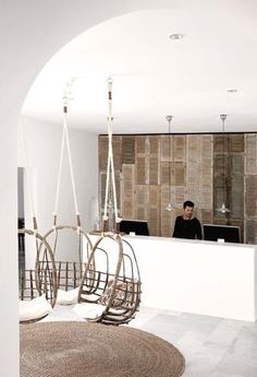 a man sitting at a reception desk in front of a wall with wooden panels on it