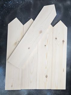 two pieces of wood are laying next to each other on a black surface with space in the background