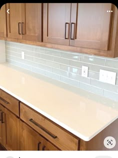 a white counter top in a kitchen next to wooden cabinets