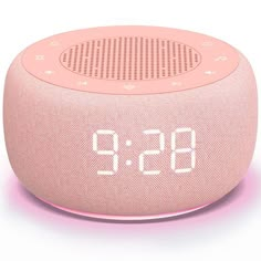 the pink alarm clock is on display in front of a white background with an orange glow