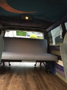 the back end of an empty van with a couch in it's seat area