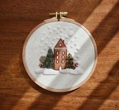 a small embroidered house with trees and snow on it